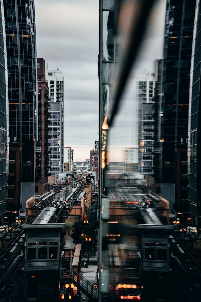 View of Chicago's elevated train with city reflections at twilight.