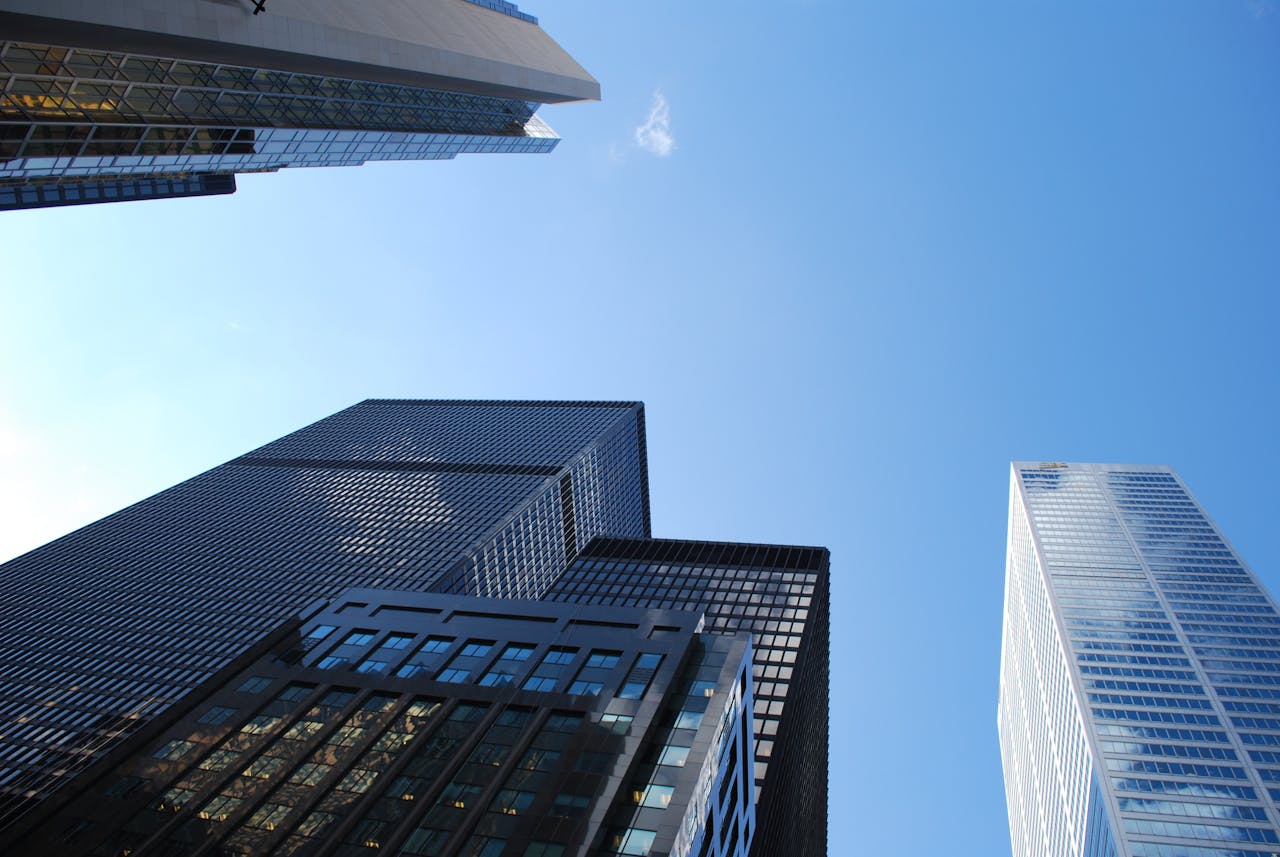 Low angle view of modern skyscrapers with a clear blue sky background.